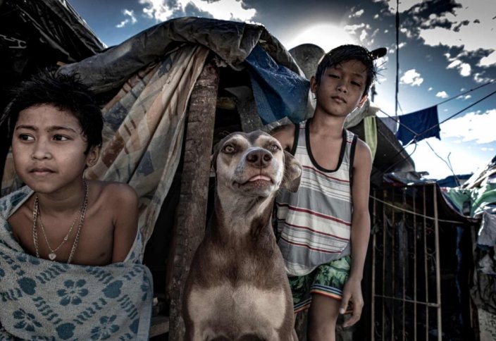 Нищета и собаки: фоторепортаж с обитаемого кладбища на Филиппинах, где люди ночуют на могилах (фото)